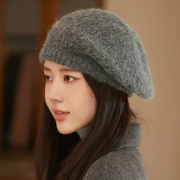 Flattering close-up of a woman wearing the Newness Parisian Women's Beret Hat, showcasing its stylish design and perfect fit. The hat is a rich, deep color that complements her complexion.