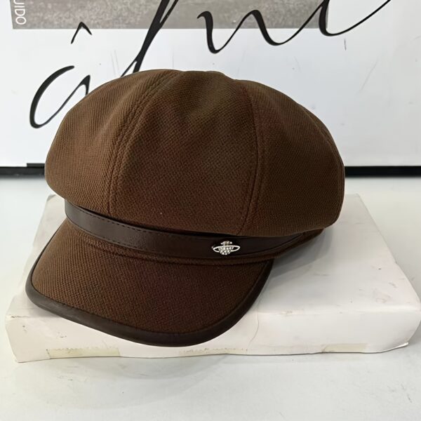 Stylish pumpkin colored beret with a metallic universe accessory showcasing its lightweight polyester fabric and toggle closure