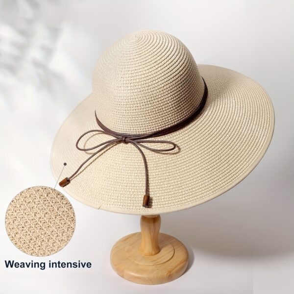 Stylish woman wearing a Newness St. Tropez Wide Brim Straw Hat, showcasing its foldable design and chic appearance.