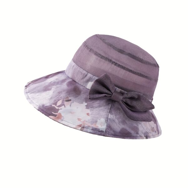 Stylish woman wearing Newness Riviera Women's Sun Hat, enjoying a sunny day at the beach.
