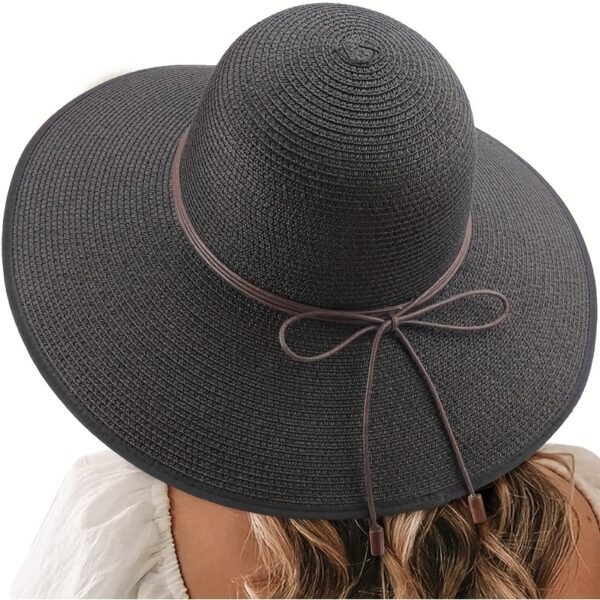 Stylish woman wearing a Newness St. Tropez Wide Brim Straw Hat, showcasing its foldable design and chic appearance.