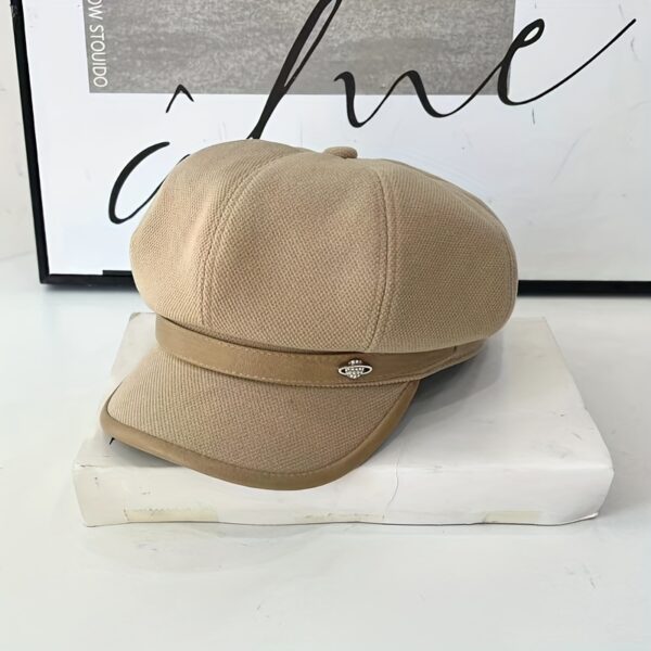 Stylish pumpkin colored beret with a metallic universe accessory showcasing its lightweight polyester fabric and toggle closure