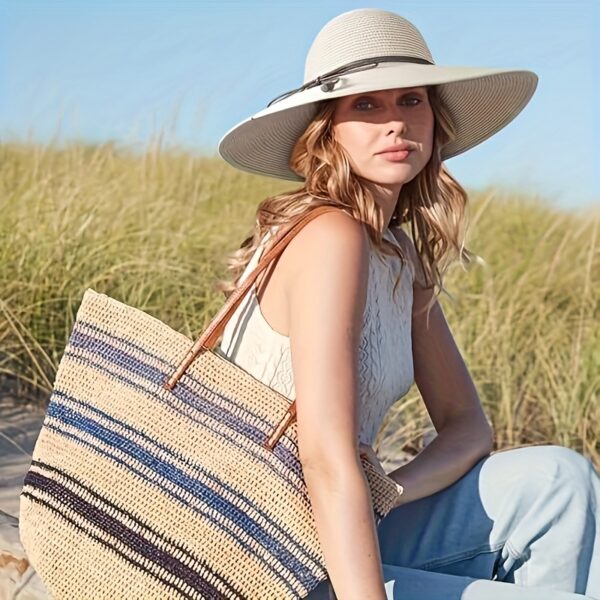Stylish woman wearing a Newness St. Tropez Wide Brim Straw Hat, showcasing its foldable design and chic appearance.