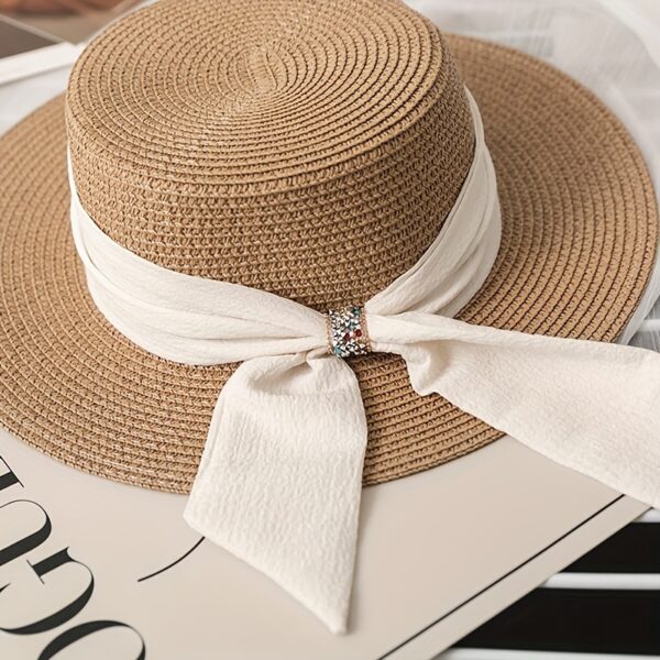 The Newness Riviera Bride Straw Hat: A stylish wide-brimmed straw hat, perfect for a beach wedding or destination bridal look. Offers elegant sun protection for the bride.