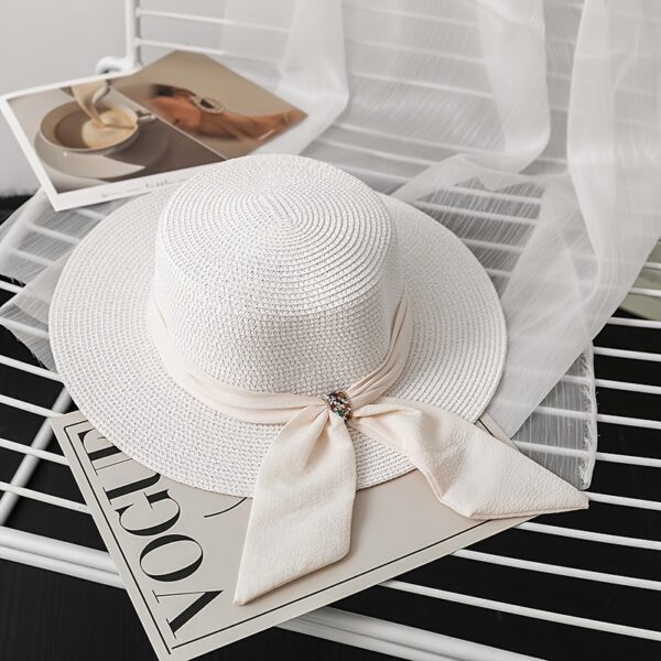 The Newness Riviera Bride Straw Hat: A stylish wide-brimmed straw hat, perfect for a beach wedding or destination bridal look. Offers elegant sun protection for the bride.
