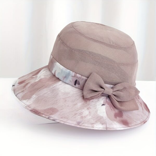Stylish woman wearing Newness Riviera Women's Sun Hat, enjoying a sunny day at the beach.