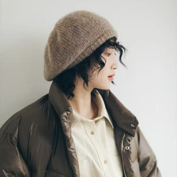 Flattering close-up of a woman wearing the Newness Parisian Women's Beret Hat, showcasing its stylish design and perfect fit. The hat is a rich, deep color that complements her complexion.