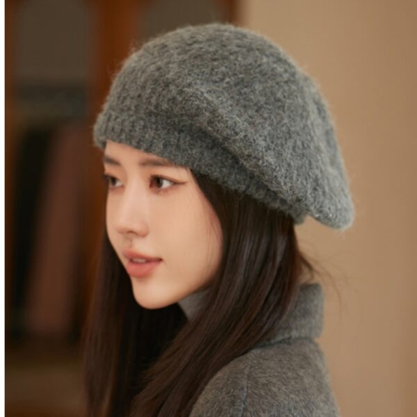 Flattering close-up of a woman wearing the Newness Parisian Women's Beret Hat, showcasing its stylish design and perfect fit. The hat is a rich, deep color that complements her complexion.