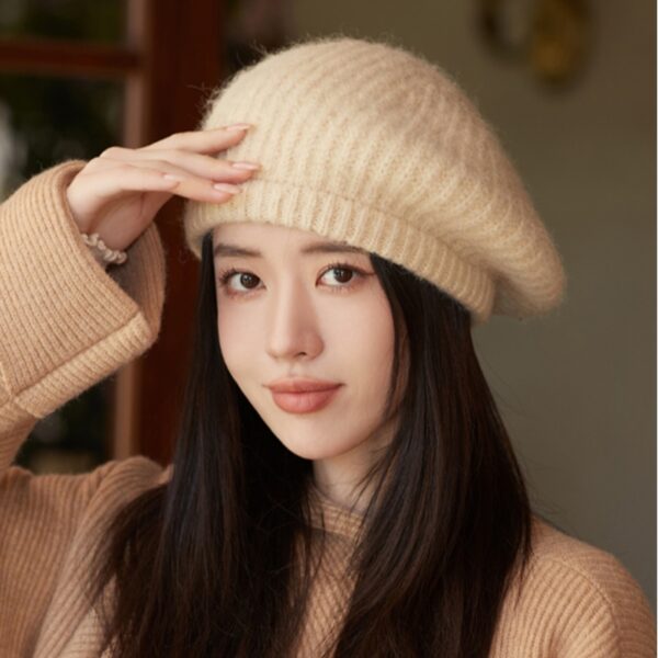 Flattering close-up of a woman wearing the Newness Parisian Women's Beret Hat, showcasing its stylish design and perfect fit. The hat is a rich, deep color that complements her complexion.