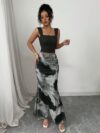 Model wearing the Newness Sunset Hues Ombre Skirt Set a chic two piece outfit featuring a gradient ombre effect in sunset colors The set includes a matching top and skirt showcasing a sophisticated and effortlessly cool summer style