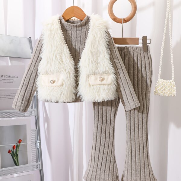 Adorable girl wearing the Newness Cozy Chic Girls Plush Vest Set smiling and playing outdoors in autumn The three piece set includes a plush vest a coordinating top and bottoms showcasing its warmth and style