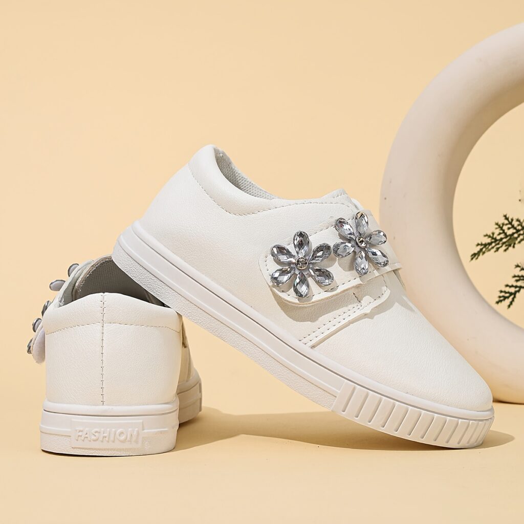 A pair of girls' Twinkle Toes sparkling floral casual sneakers, showcasing their floral design and sparkling accents. The shoes are comfortable and stylish, perfect for all-season wear.