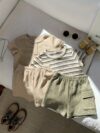 Adorable baby boy in a beige and green striped summer outfit set featuring a textured short sleeve top and matching shorts Perfect for warm weather
