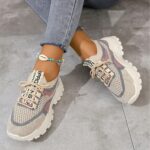 Pair of womens breathable mesh casual sneakers in white low top design with lace up closure and soft knit insole