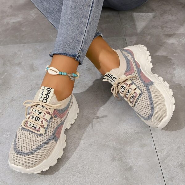 Pair of womens breathable mesh casual sneakers in white low top design with lace up closure and soft knit insole