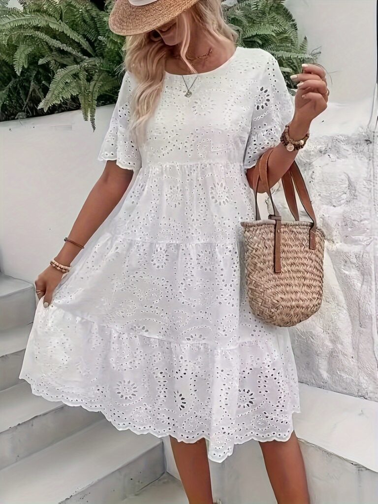 A stunning white eyelet midi dress, perfect for summer. The dress features delicate eyelet details and a flowy silhouette.