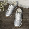 Stylish silvery gray and white low top sneakers for kids featuring a durable TPR sole breathable lining and secure lace up closure Perfect for everyday wear
