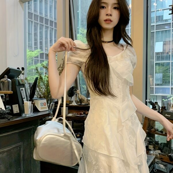 Model wearing a timeless Parisian black ruffle midi dress, showcasing its elegant silhouette and ruffle details.