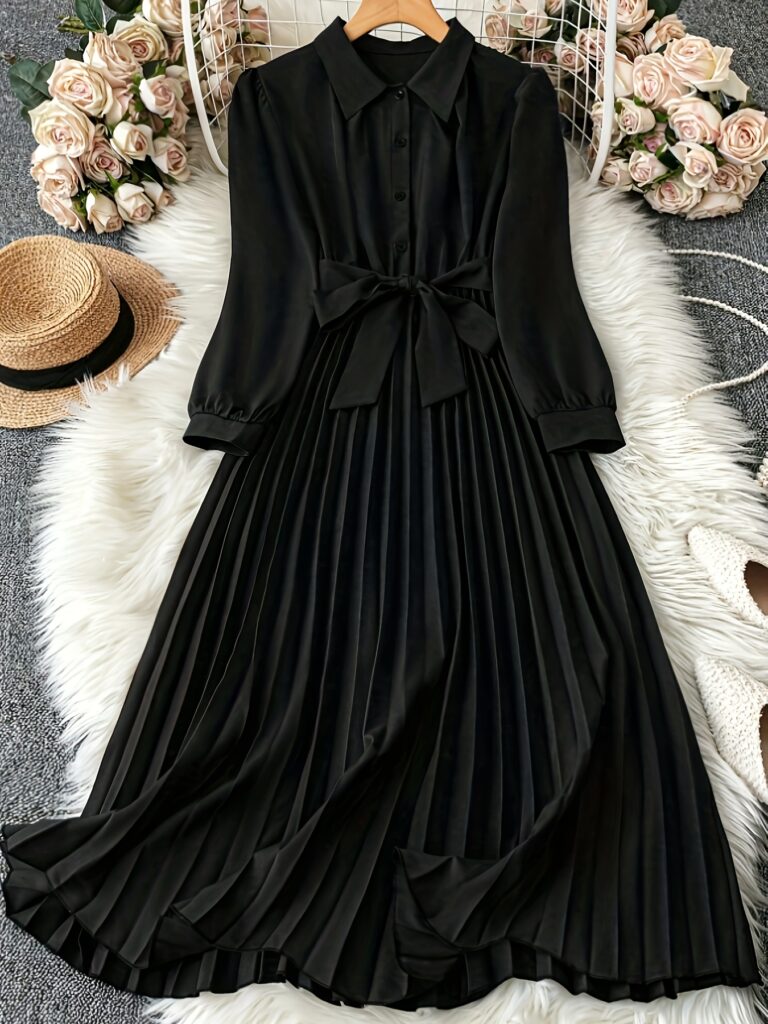 Model wearing the Newness Noir Rhapsody black pleated midi dress, showcasing its elegant drape and midi length.