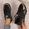 Womens black slip on sneakers with golden accents showcasing the breathable knit upper and flexible sole