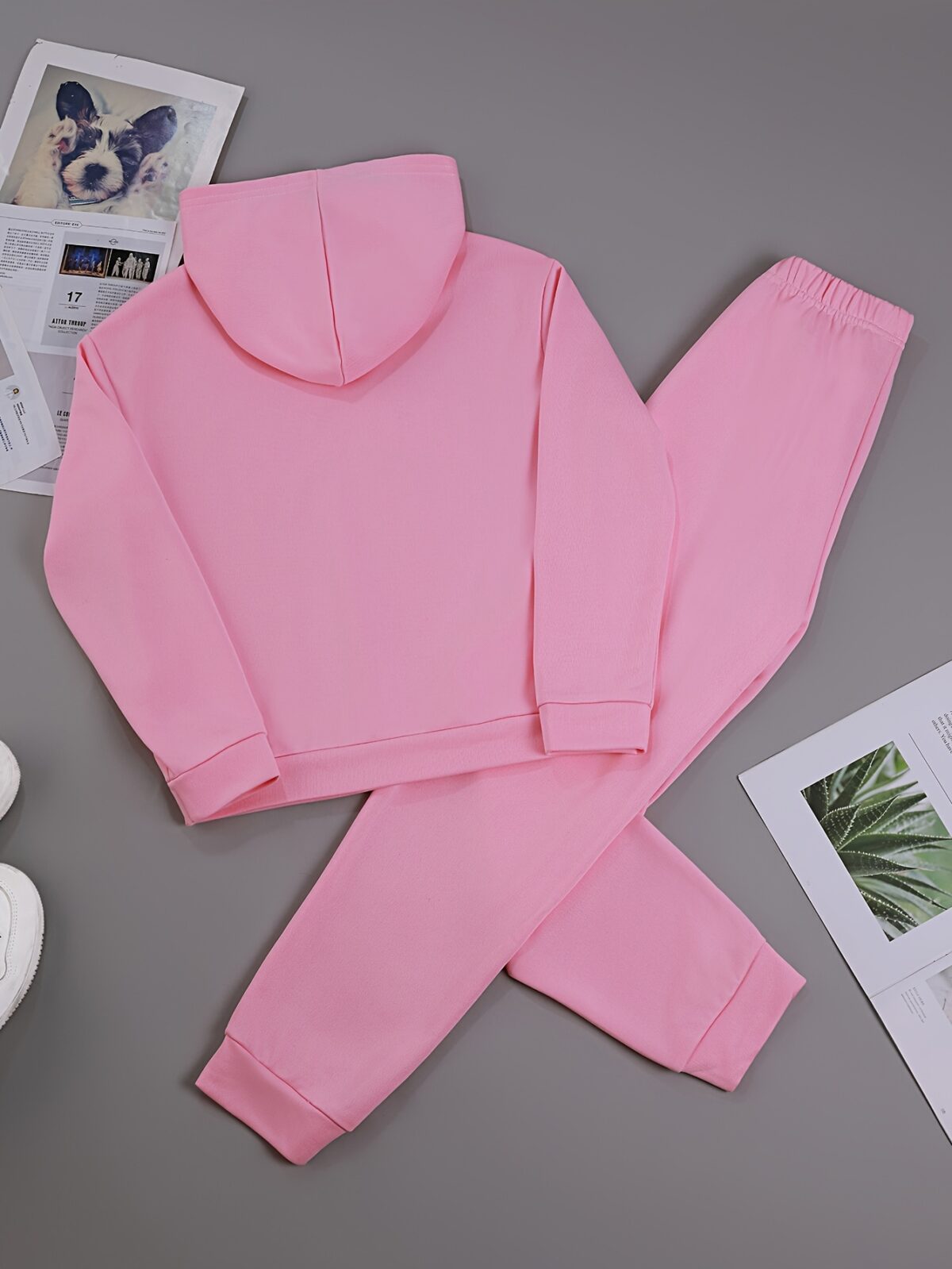Adorable girl wearing a playful spring hues hooded sports suit featuring a charming cartoon print Perfect for spring adventures
