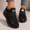Womens black slip on sneakers with golden accents showcasing the breathable knit upper and flexible sole