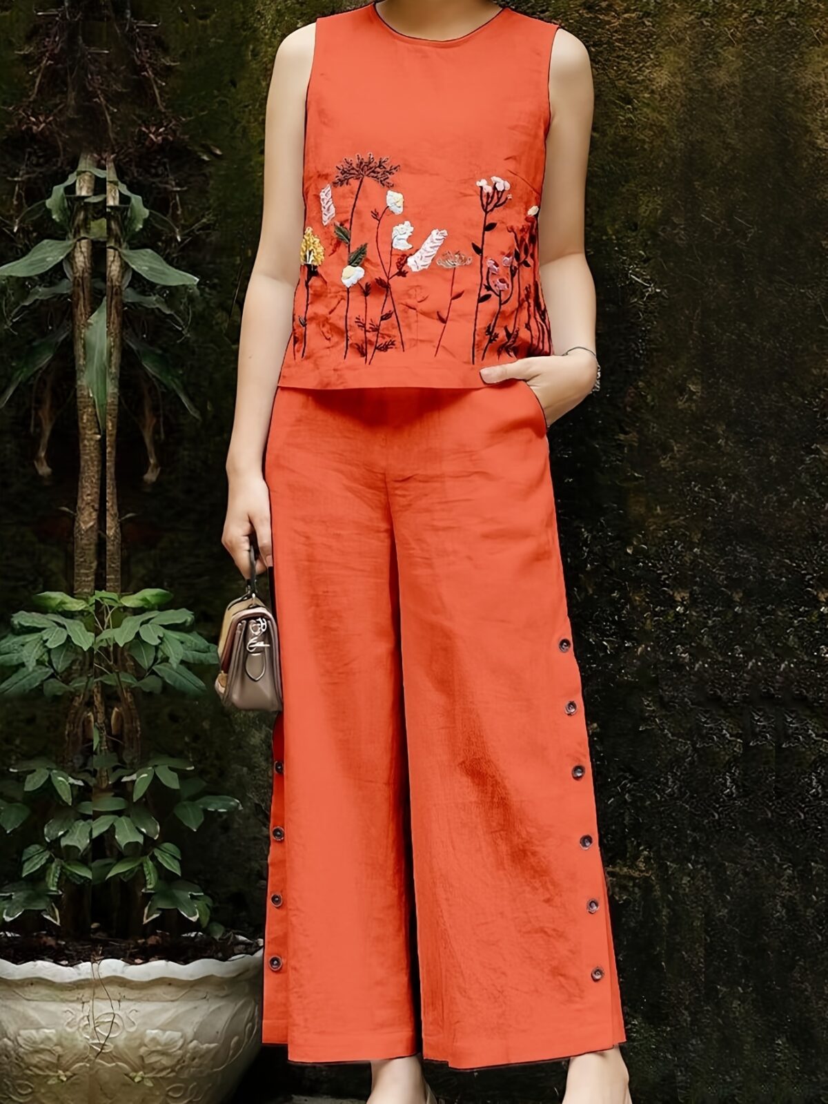 Embrace effortless chic in the Marrakech Sunset Embroidered Summer Jumpsuit This vibrant orange jumpsuit features intricate butterfly embroidery and a flattering wide leg silhouette