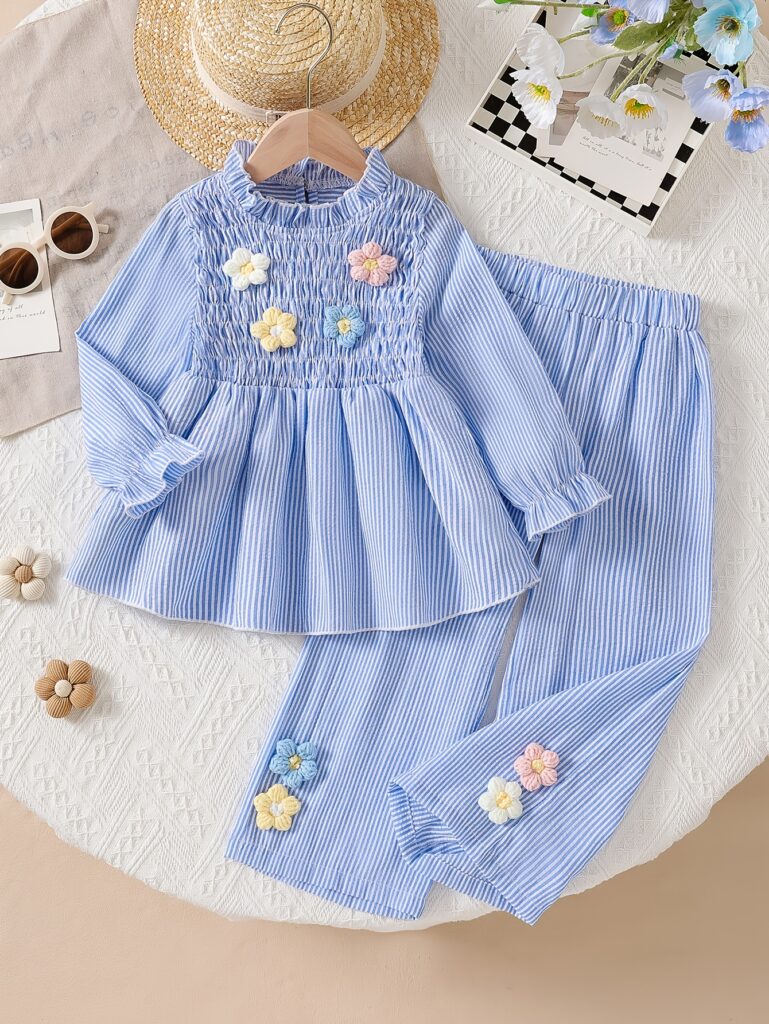 Adorable girl wearing Newness' Parisian Chic Girls' Striped Two-Piece Set, perfect for autumn. The outfit features a stylish striped top and matching bottoms, offering both comfort and chic style.