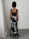 Model wearing the Newness Sunset Hues Ombre Skirt Set a chic two piece outfit featuring a gradient ombre effect in sunset colors The set includes a matching top and skirt showcasing a sophisticated and effortlessly cool summer style