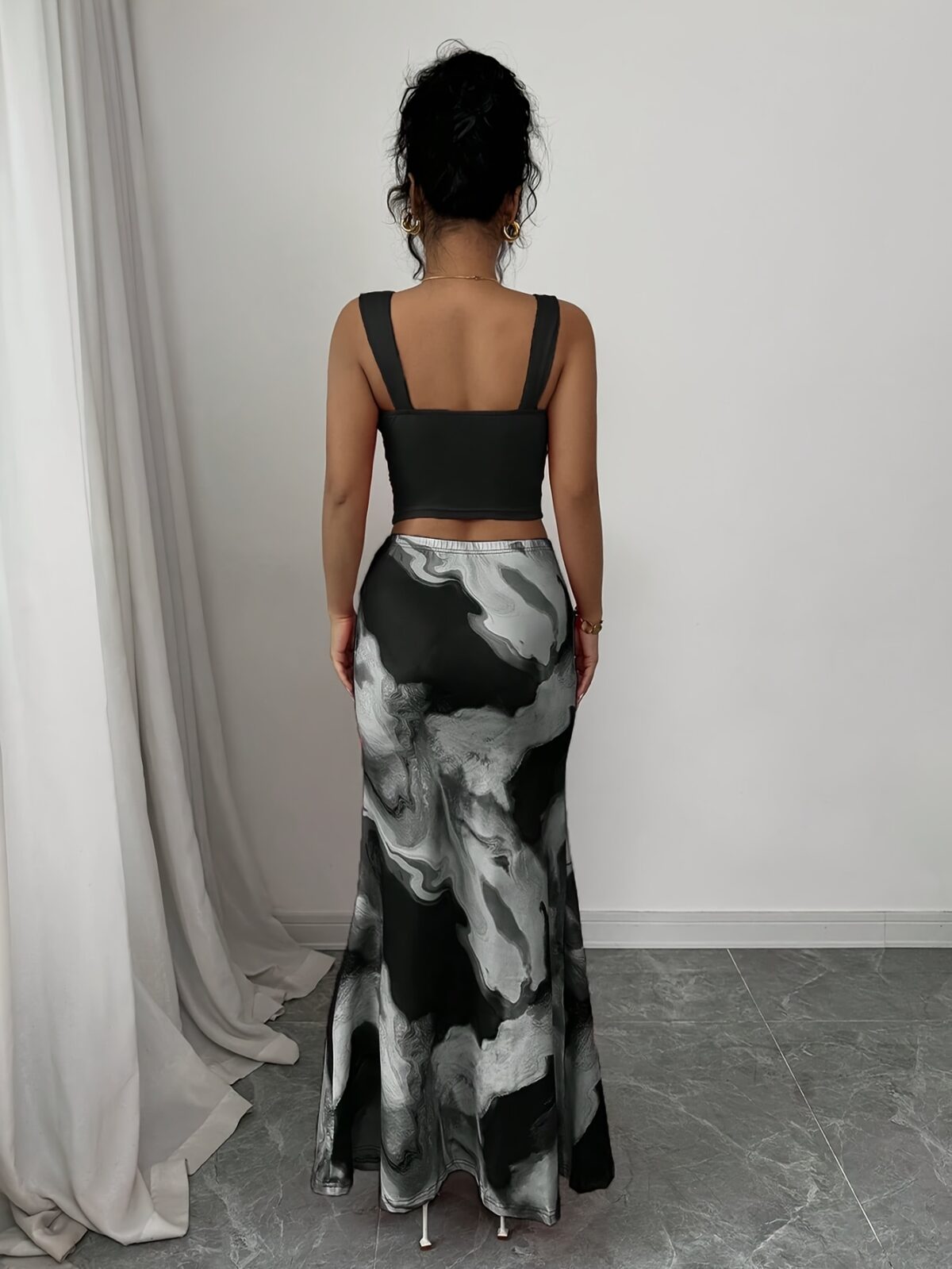 Model wearing the Newness Sunset Hues Ombre Skirt Set a chic two piece outfit featuring a gradient ombre effect in sunset colors The set includes a matching top and skirt showcasing a sophisticated and effortlessly cool summer style
