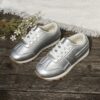 Stylish silvery gray and white low top sneakers for kids featuring a durable TPR sole breathable lining and secure lace up closure Perfect for everyday wear