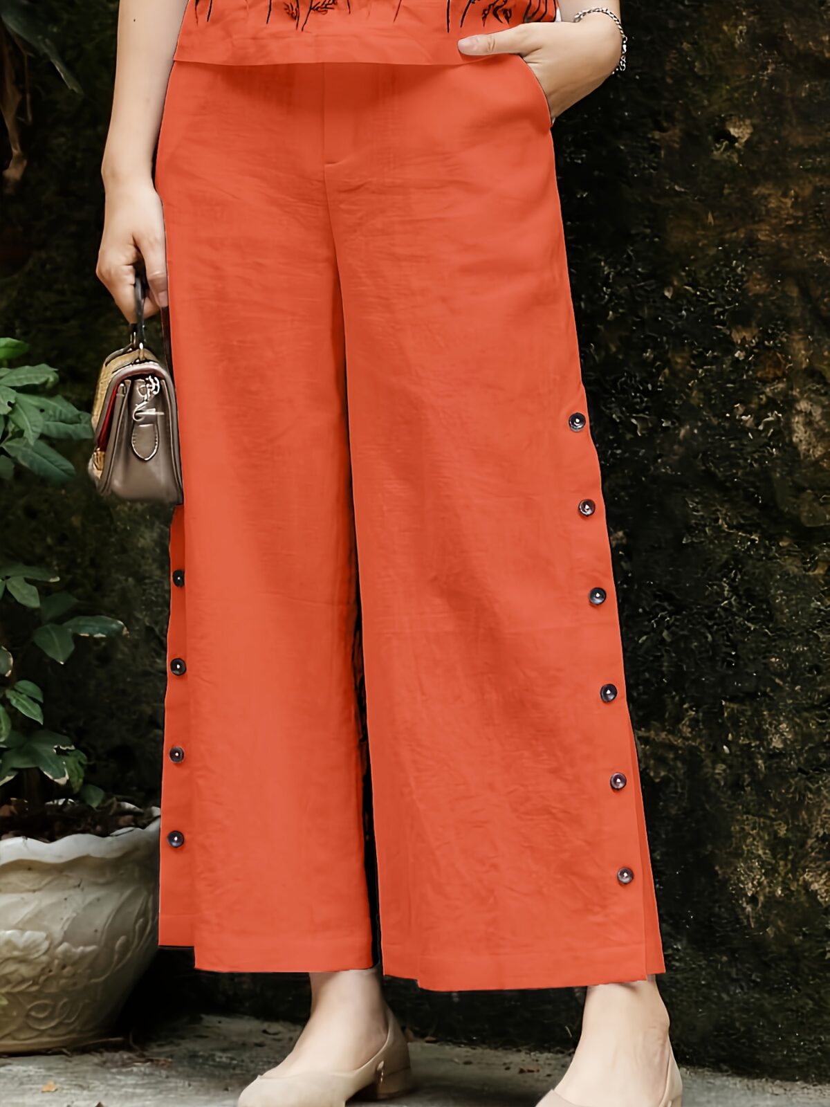 Embrace effortless chic in the Marrakech Sunset Embroidered Summer Jumpsuit This vibrant orange jumpsuit features intricate butterfly embroidery and a flattering wide leg silhouette