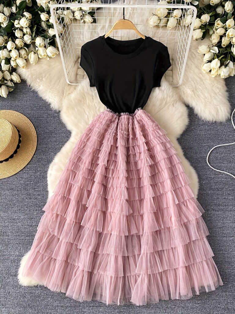 Model wearing the Newness Blush Dream Tiered Midi Dress, a blush-colored tiered midi dress perfect for summer events.