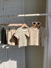 Adorable baby boy in a beige and green striped summer outfit set featuring a textured short sleeve top and matching shorts Perfect for warm weather