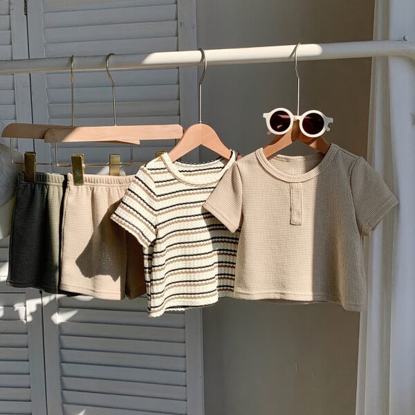 Adorable baby boy in a beige and green striped summer outfit set featuring a textured short sleeve top and matching shorts Perfect for warm weather