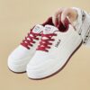 Womens white low top sneakers with red laces showcasing the side profile of the shoe