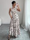 Model wearing the Newness Cairo Nights Geometric Print Dress a chic belted dress perfect for summer featuring a striking geometric print