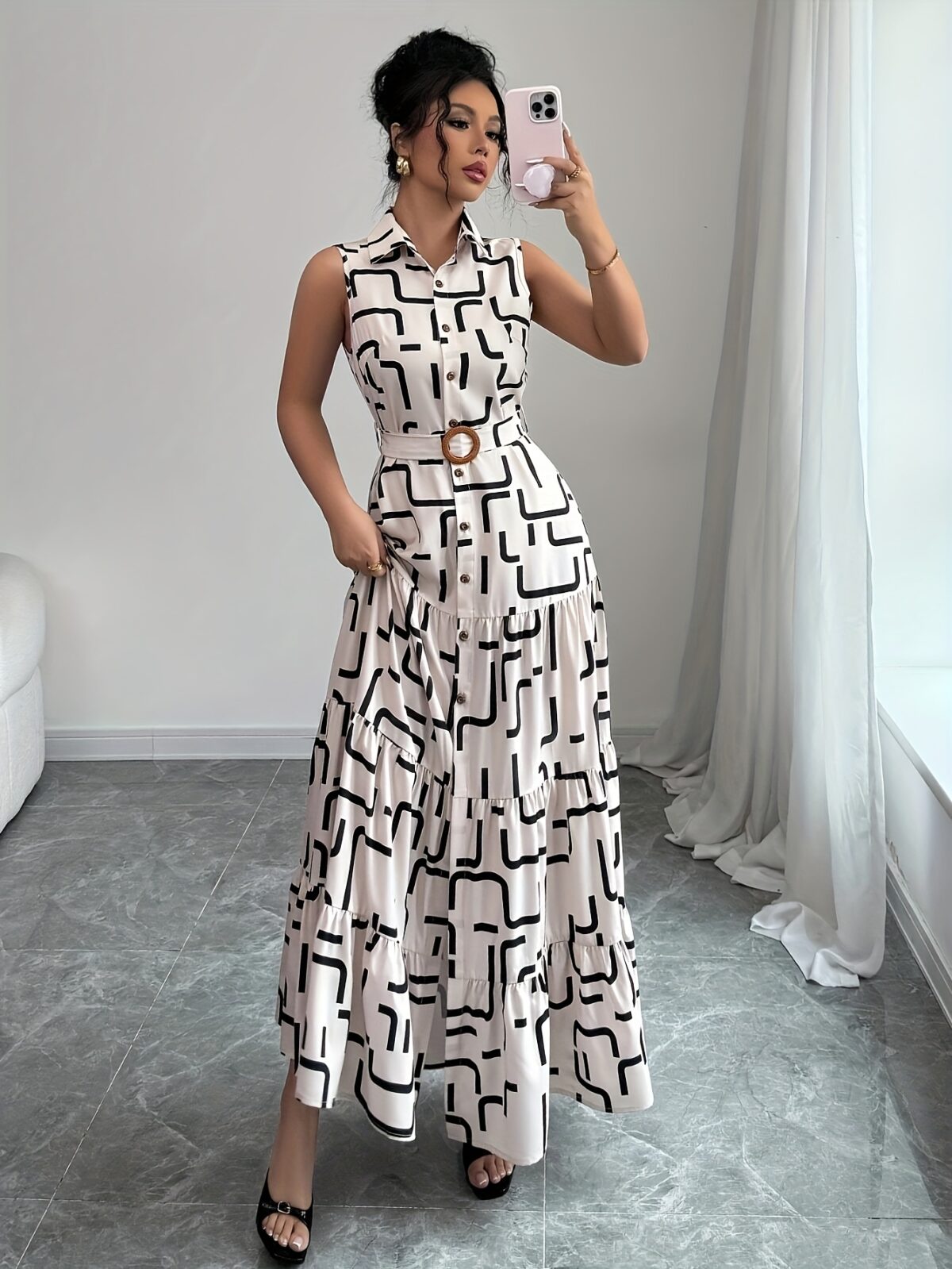 Model wearing the Newness Cairo Nights Geometric Print Dress a chic belted dress perfect for summer featuring a striking geometric print