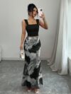 Model wearing the Newness Sunset Hues Ombre Skirt Set a chic two piece outfit featuring a gradient ombre effect in sunset colors The set includes a matching top and skirt showcasing a sophisticated and effortlessly cool summer style