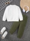 Adorable boy modeling the Newness Cozy Comrade 2 Piece Set featuring a beige star embroidered sweatshirt and matching corduroy cargo pants Perfect for fall and winter