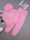 Adorable girl wearing a playful spring hues hooded sports suit featuring a charming cartoon print Perfect for spring adventures