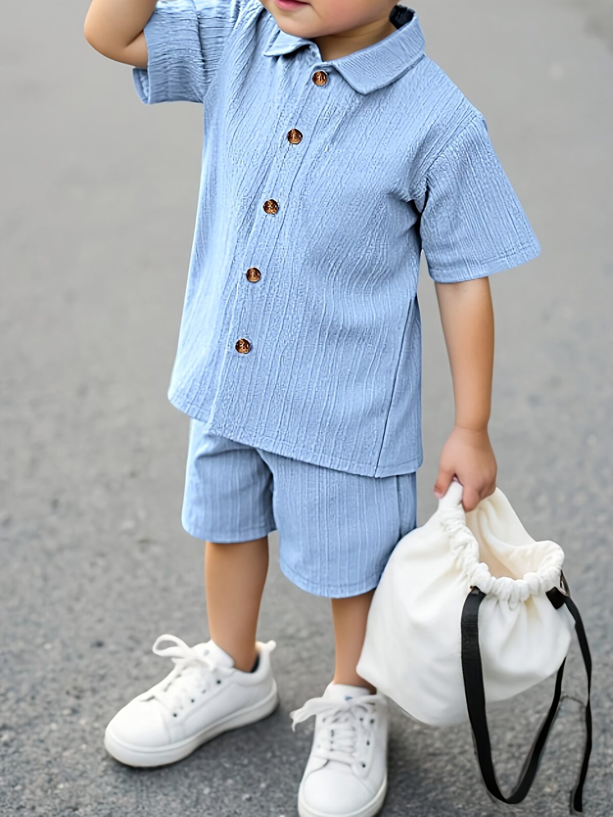 Adorable boy playing outdoors wearing the Newness Summer Breeze Boys Casual Short Set The set is comfortable and perfect for playtime