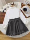 A charming little girl in a classic schoolgirl outfit smiling and playful Newness