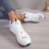 Newness Nova Minimalist White Sneakers A pair of sleek white minimalist sneakers showcasing comfort and versatility ideal for any occasion