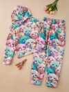 Adorable girl wearing a playful spring hues hooded sports suit featuring a charming cartoon print Perfect for spring adventures