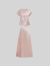 Flatlay of the Newness Bisous Rosé pink pleated midi set showcasing the skirt and top separately and together The set is a beautiful shade of pink and features delicate pleats