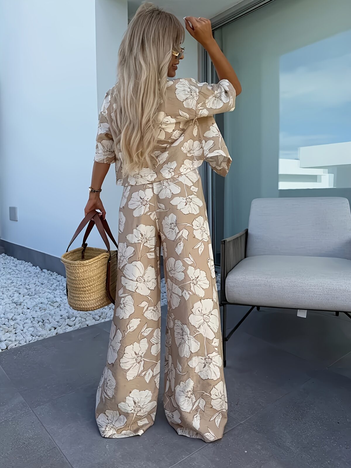 Stylish woman wearing the Newness Summer Breeze Floral Print Set posing outdoors in summery lighting The set includes a flowy top and coordinating shorts or skirt showcasing the beautiful floral print