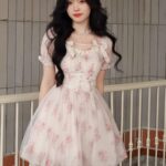 Model wearing Newnesss Blushing Blossom Floral Mini Dress a charming summer mini dress with a romantic floral print The dress is perfect for summer occasions