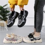 Pair of stylish thick soled womens casual sport shoes in a trendy color shown from the side