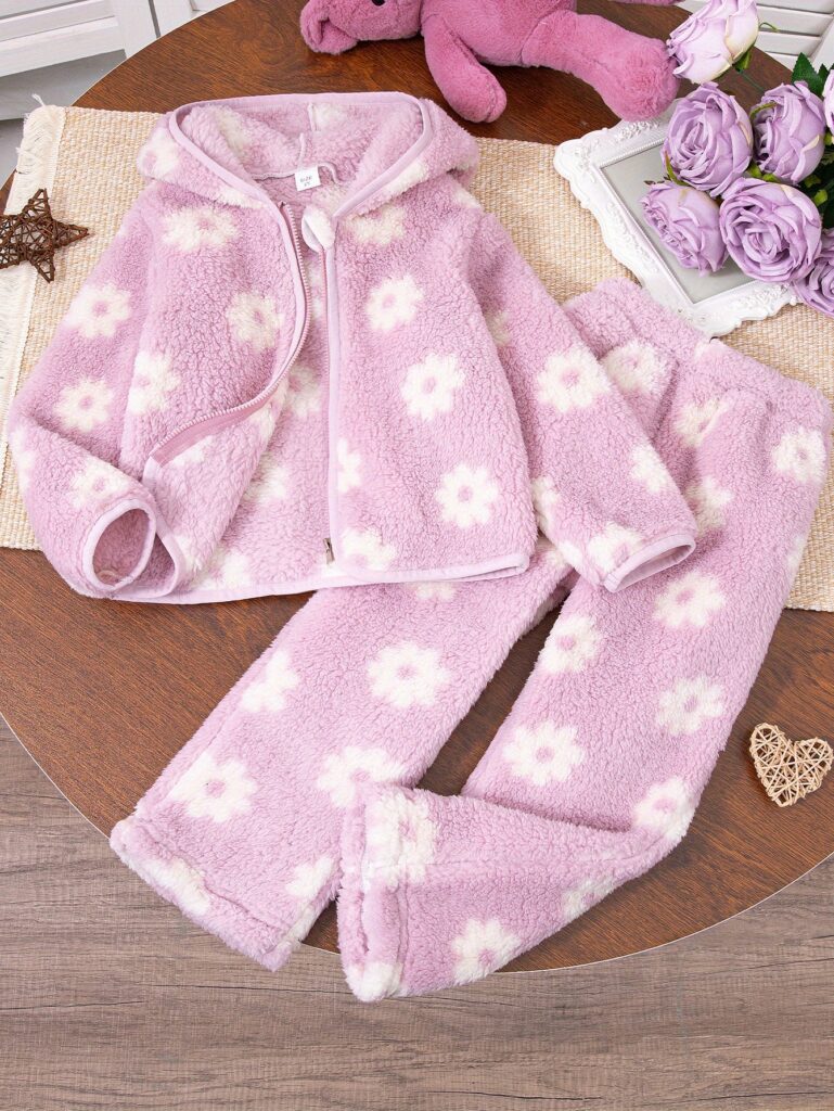 Adorable girl wearing the Newness Winter Wonderland Girls Floral Winter Set, a charming floral outfit perfect for winter. She looks warm and happy playing in the snow.
